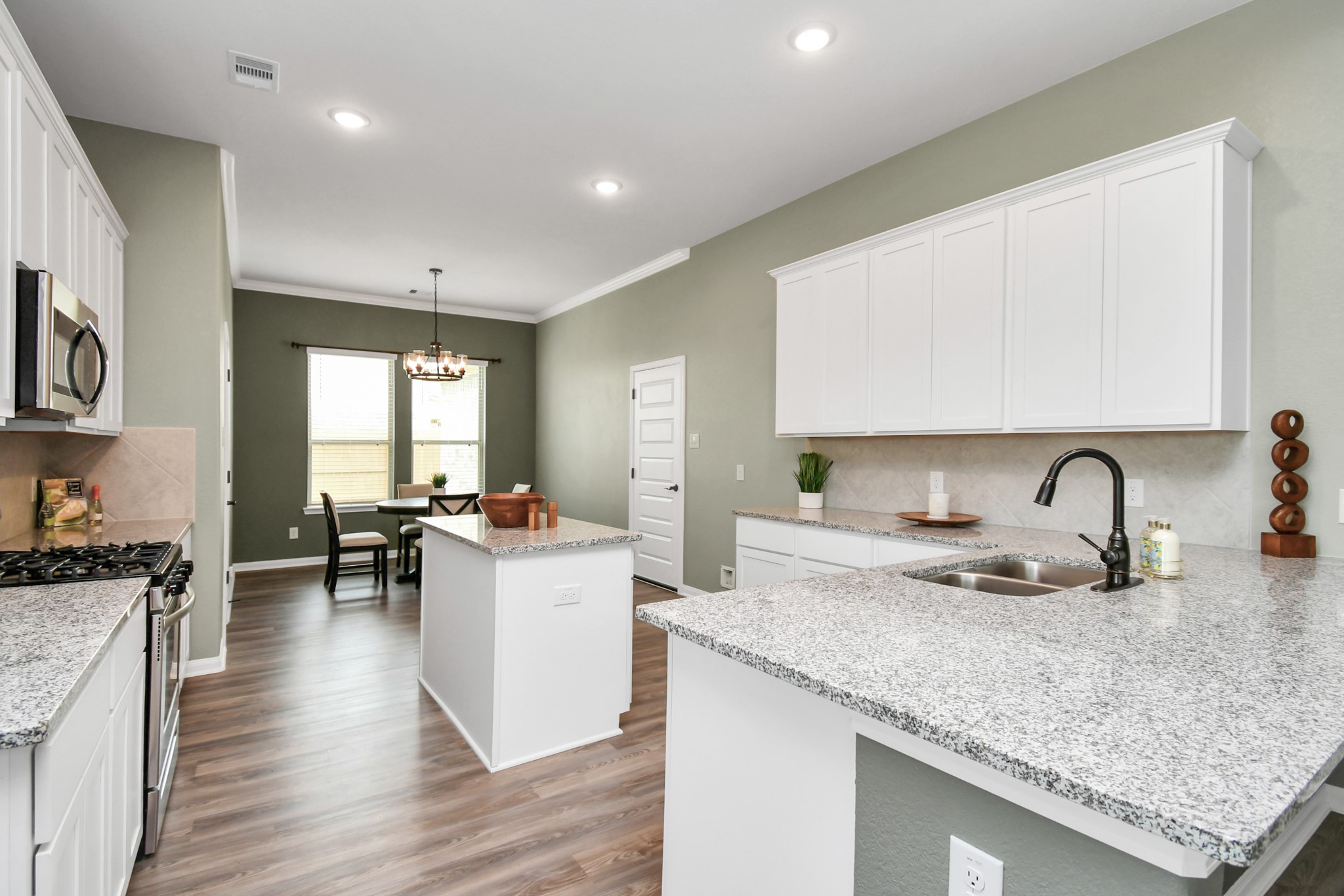 395 Hunter Ranch Way Dayton, TX 77535 - Photo 14 of 42 a kitchen with a sink a stove and cabinets