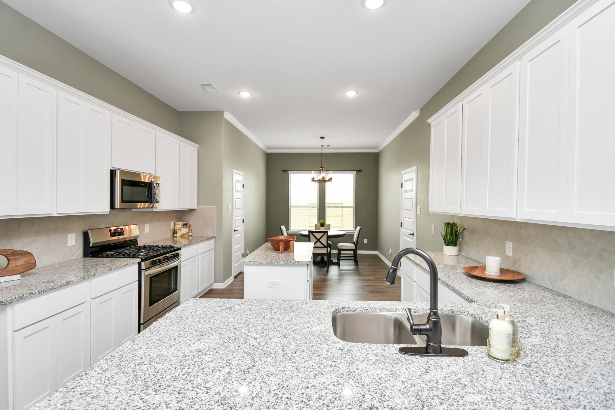 395 Hunter Ranch Way Dayton, TX 77535 - Photo 16 of 42 a kitchen with sink a stove and cabinets
