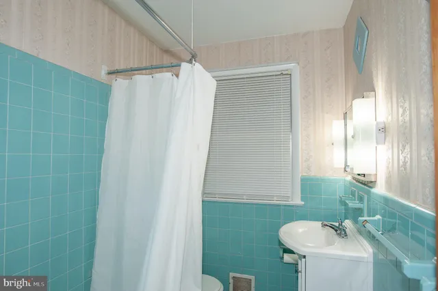 a bathroom with a sink a toilet a mirror and shower