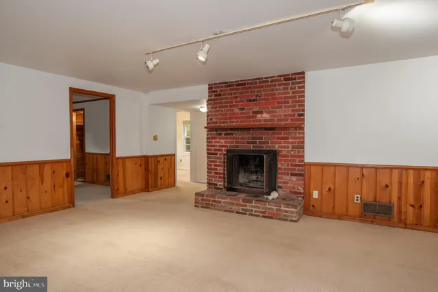 a view of an empty room with a fireplace and a window
