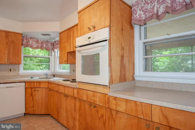a view of a kitchen with a sink and dishwasher with wooden floor