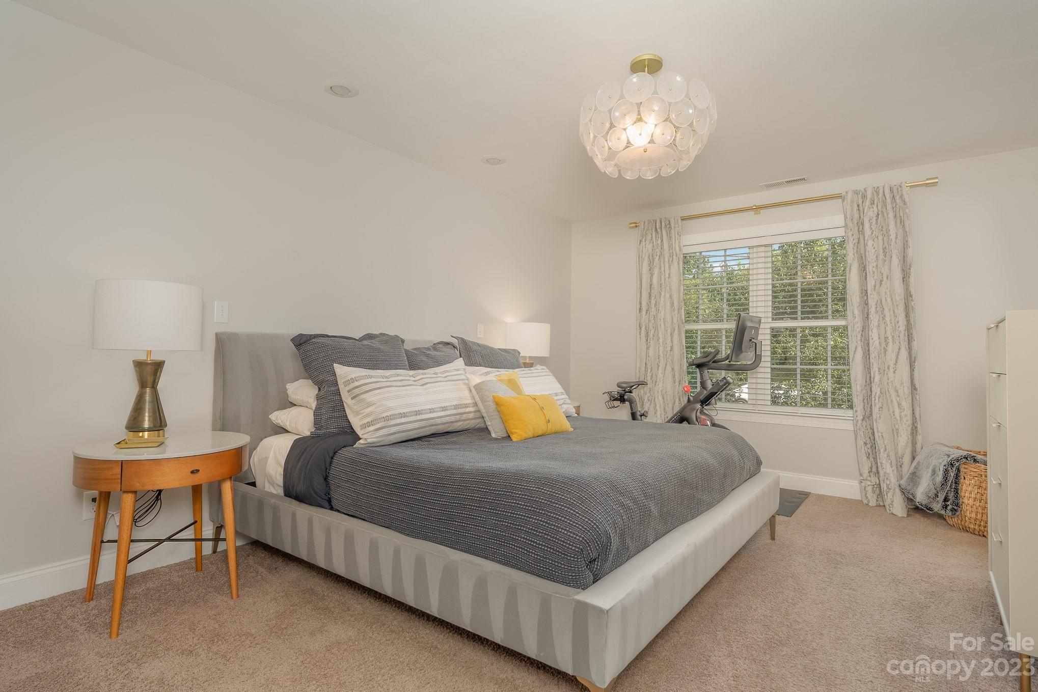 5816 Sharon Road Charlotte, NC 28210 - Photo 17 of 33 a spacious bedroom with a bed and a table