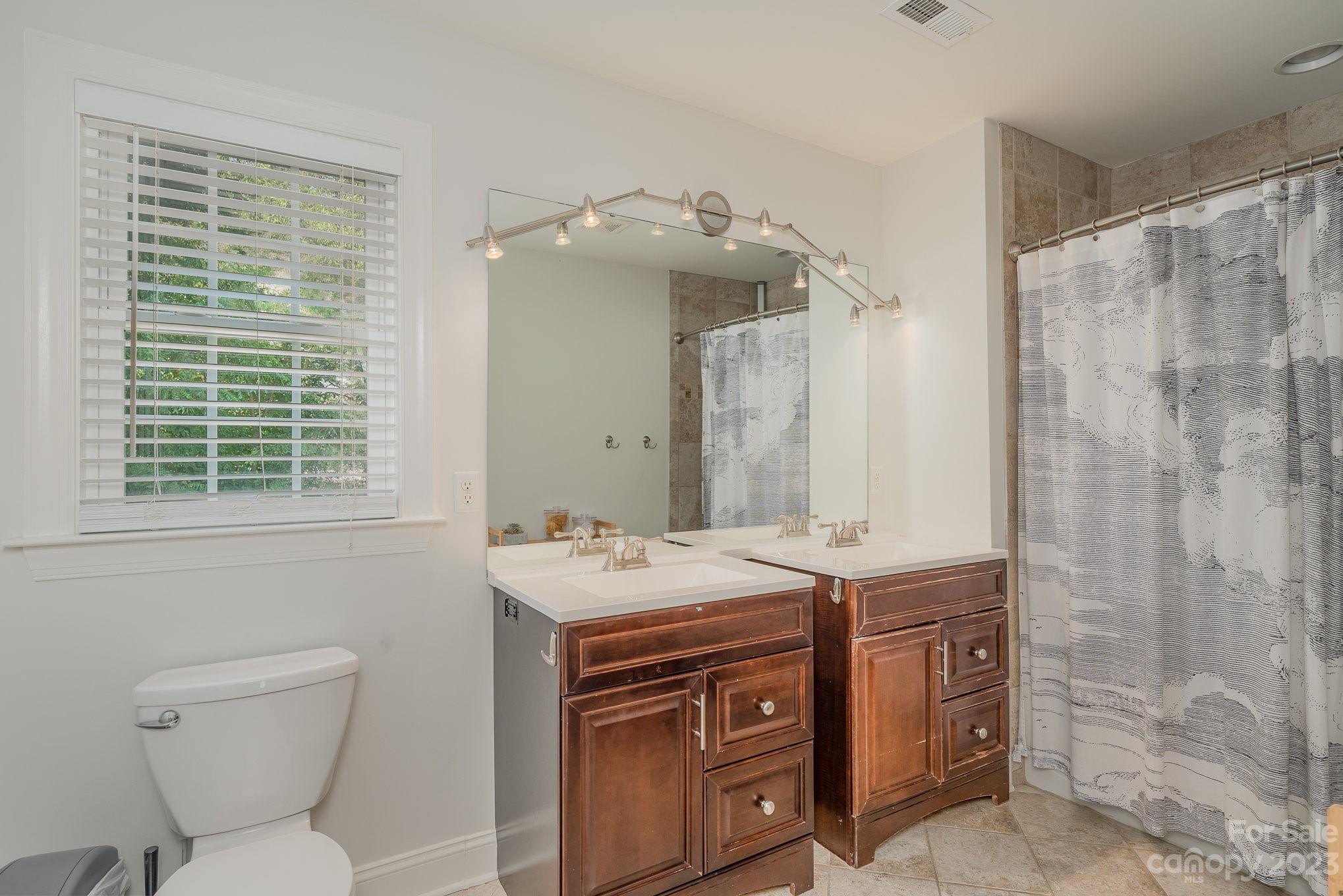 5816 Sharon Road Charlotte, NC 28210 - Photo 23 of 33 a bathroom with a sink toilet and shower
