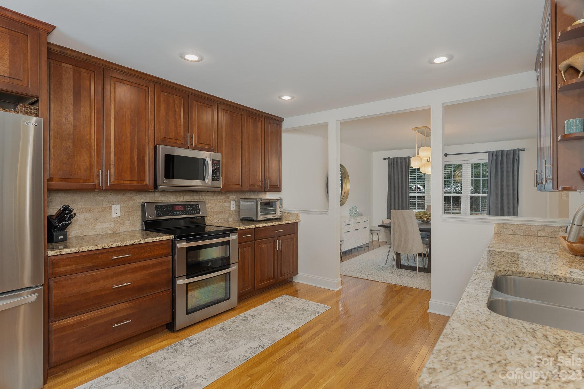 5816 Sharon Road Charlotte, NC 28210 - Photo 9 of 33 a large kitchen with stainless steel appliances granite countertop a stove and a sink