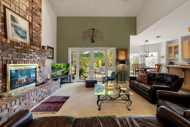 a living room with furniture fireplace and a large window