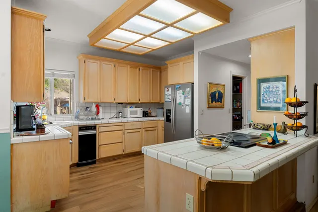a kitchen with lots of counter top space a sink appliances and cabinets