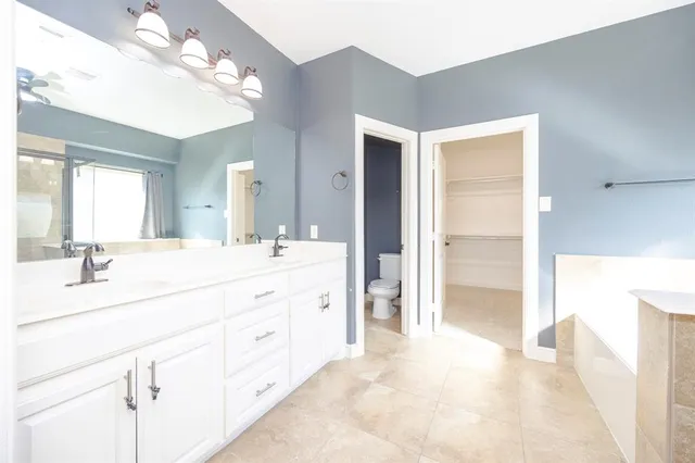 a spacious bathroom with a shower sink and a mirror