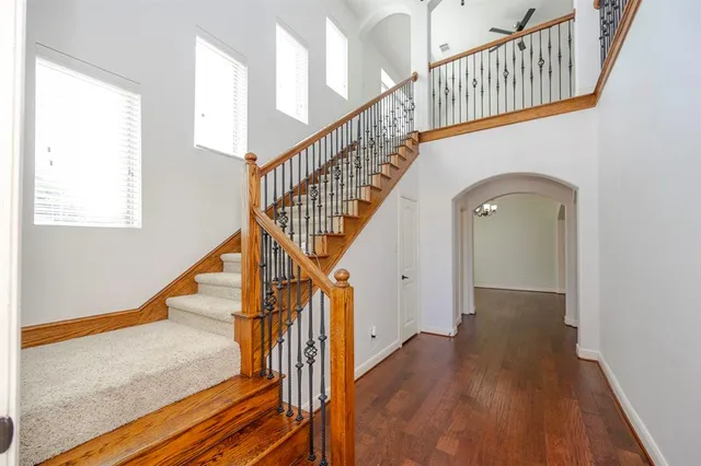 a view of staircase with lots of frames on wall and wooden floor