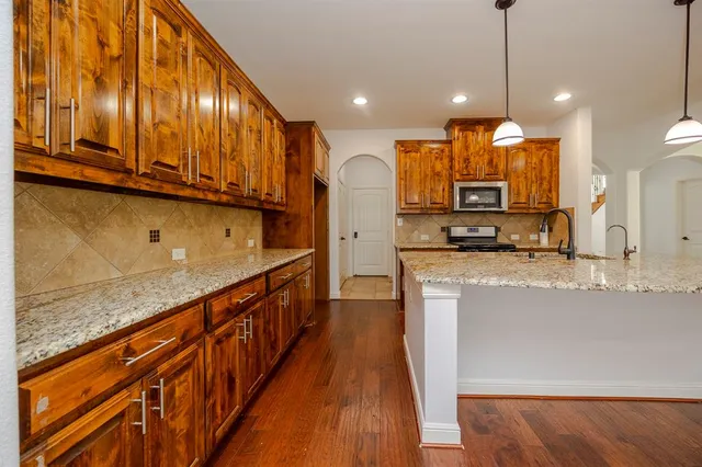 a kitchen with stainless steel appliances granite countertop a stove a sink and a refrigerator