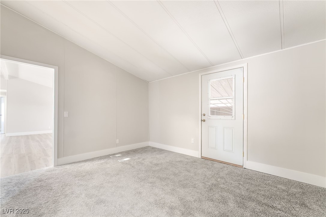 5552 Aldama Road Las Vegas, NV 89122 - Photo 22 of 35 Carpeted empty room featuring lofted ceiling and b