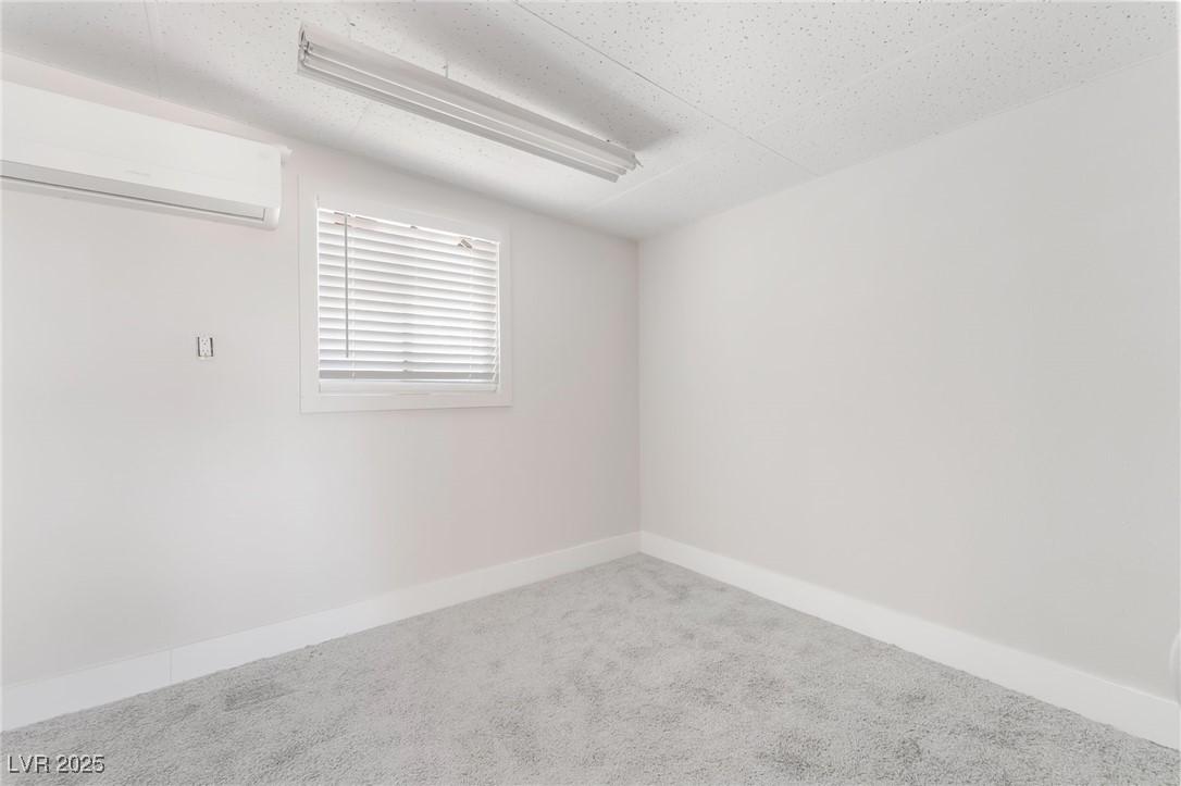 5552 Aldama Road Las Vegas, NV 89122 - Photo 29 of 35 Carpeted spare room featuring a wall unit AC and b