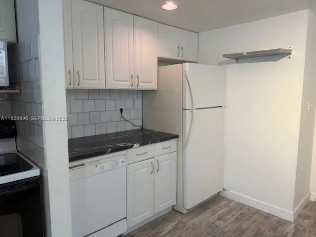 a kitchen with a refrigerator and cabinets