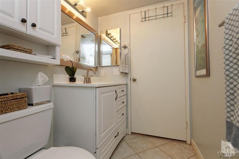 1007 Waltham Road, Unit F Simi Valley, CA 93065 - Photo 19 of 32 a bathroom with a sink a toilet and mirror