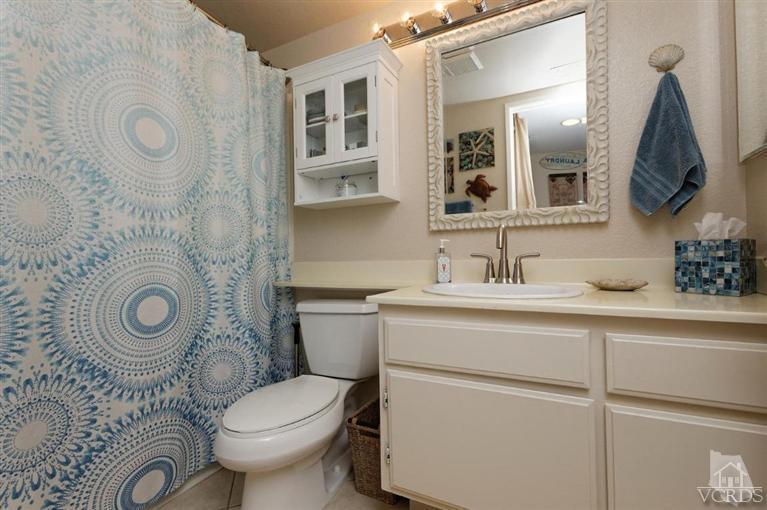 1007 Waltham Road, Unit F Simi Valley, CA 93065 - Photo 22 of 32 a bathroom with a granite countertop toilet sink and mirror