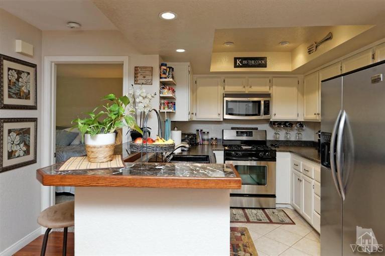 1007 Waltham Road, Unit F Simi Valley, CA 93065 - Photo 6 of 32 a kitchen with stainless steel appliances a sink a stove a microwave a refrigerator cabinets and a dining table