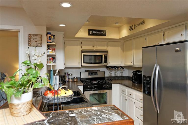 1007 Waltham Road, Unit F Simi Valley, CA 93065 - Photo 7 of 32 a kitchen with stainless steel appliances kitchen island granite countertop a refrigerator a stove a microwave and cabinets