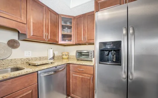a kitchen with stainless steel appliances granite countertop a refrigerator and a sink