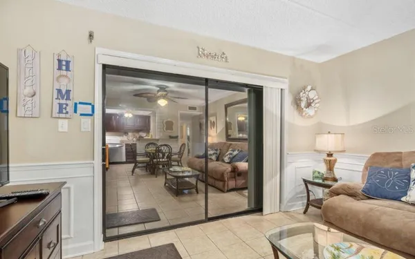 a living room with furniture and a glass door shower