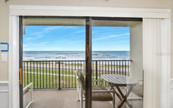a view of a porch with a table and chairs