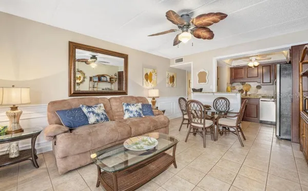 a living room with furniture a chandelier and a dining table