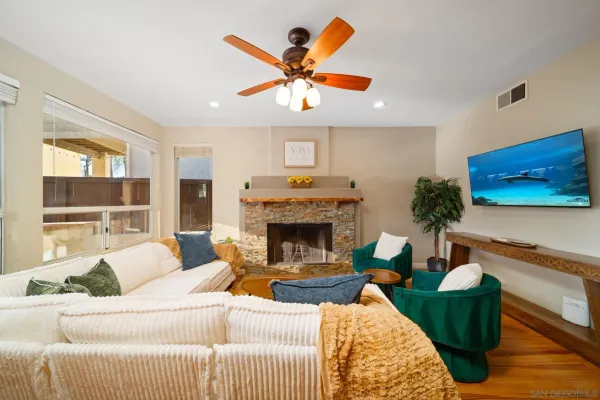 a living room with furniture kitchen view and a chandelier