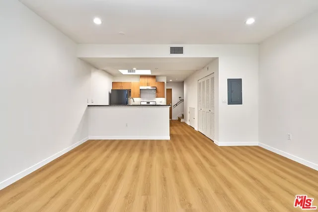 a view of a kitchen with wooden floor and a sink