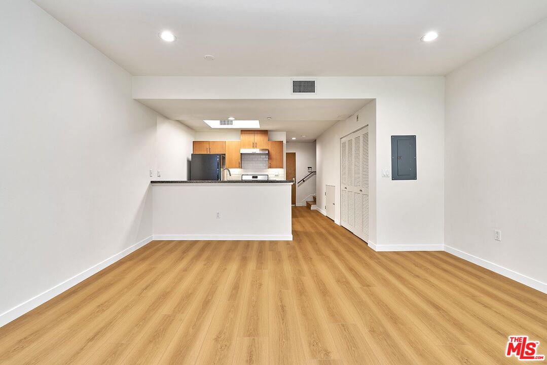 a view of a kitchen with wooden floor and a sink