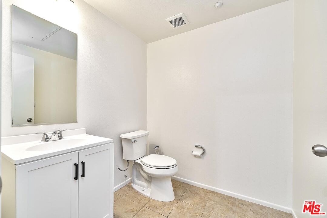2864 Sunset Place, Unit 203 Los Angeles, CA 90005 - Photo 15 of 21 a bathroom with a toilet a sink and a mirror