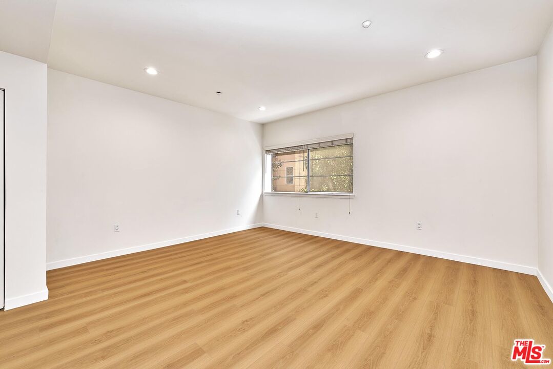 2864 Sunset Place, Unit 203 Los Angeles, CA 90005 - Photo 8 of 21 a view of an empty room with wooden floor and a window