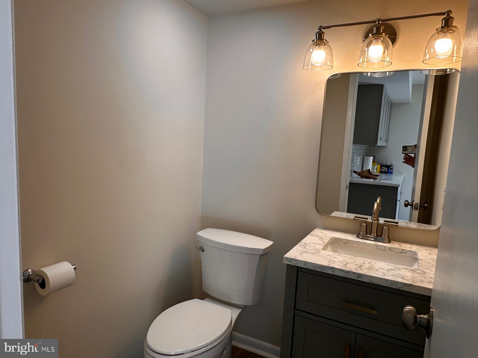 12800 Asbury Drive Fort Washington, MD 20744 - Photo 24 of 53 a bathroom with a granite countertop toilet sink and mirror