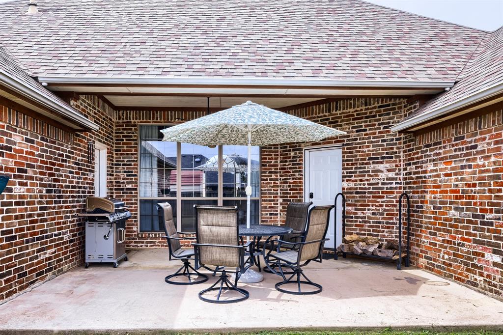 603 Ash Street Pilot Point, TX 76258 - Photo 26 of 28 Covered outdoor patio featuring brick siding and a multi-toned shingle roof