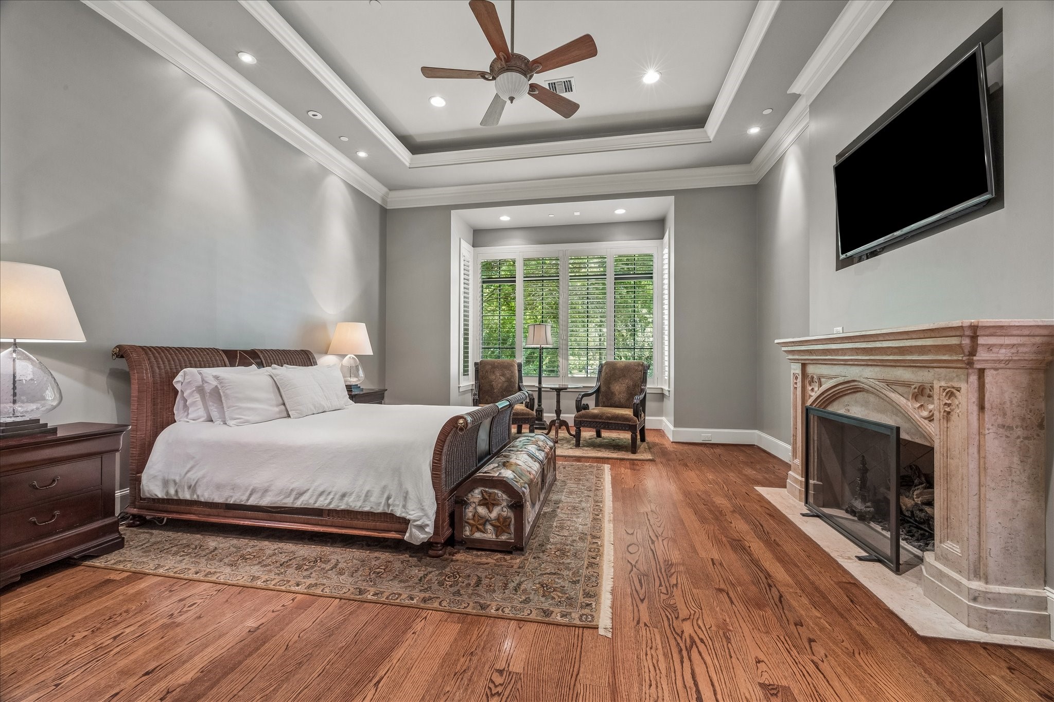802 Country Lane Houston, TX 77024 - Photo 15 of 34 a spacious bedroom with a bed a fireplace and a flat tv screen on dresser