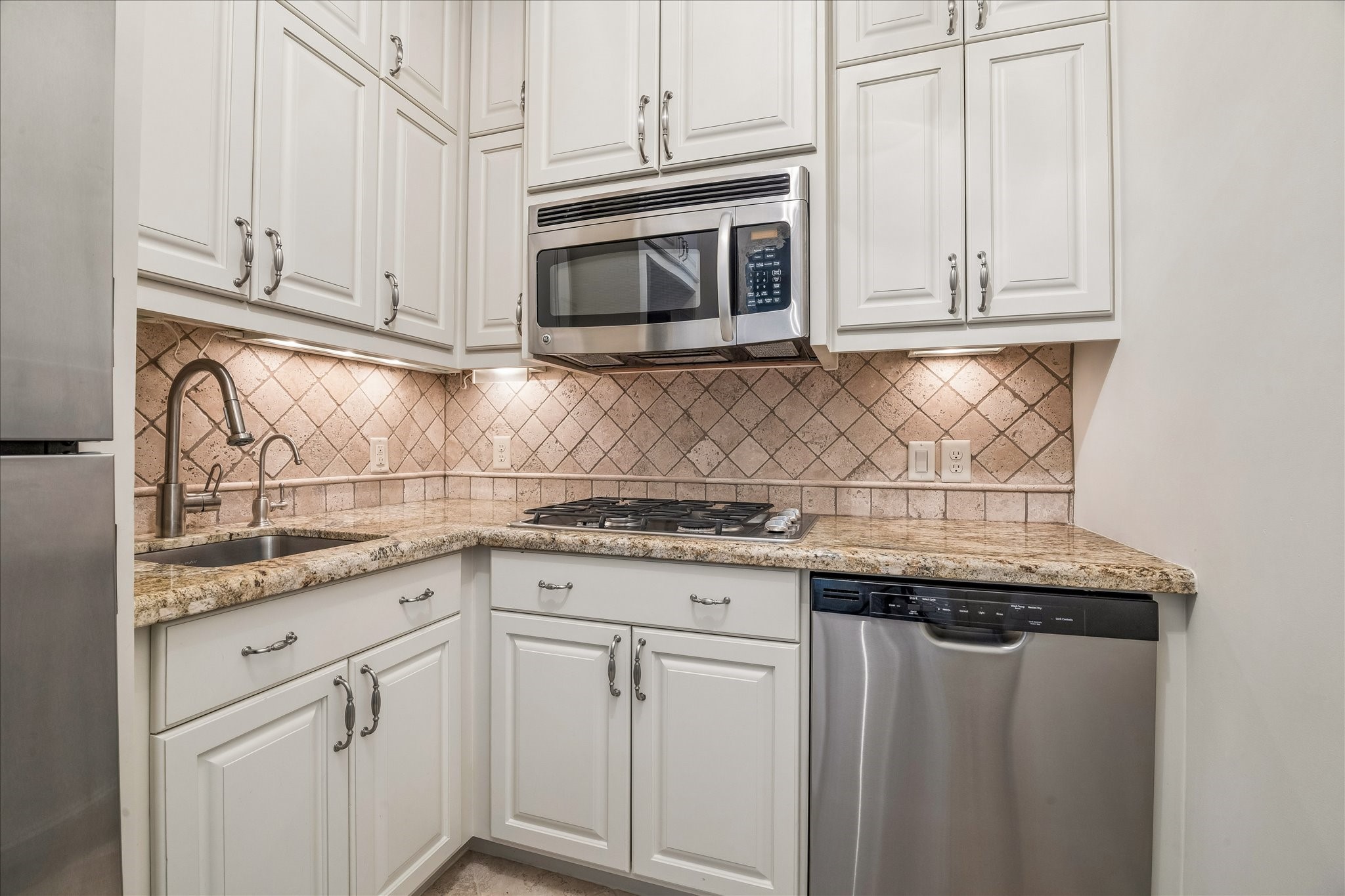 802 Country Lane Houston, TX 77024 - Photo 22 of 34 a kitchen with granite countertop white cabinets and white appliances