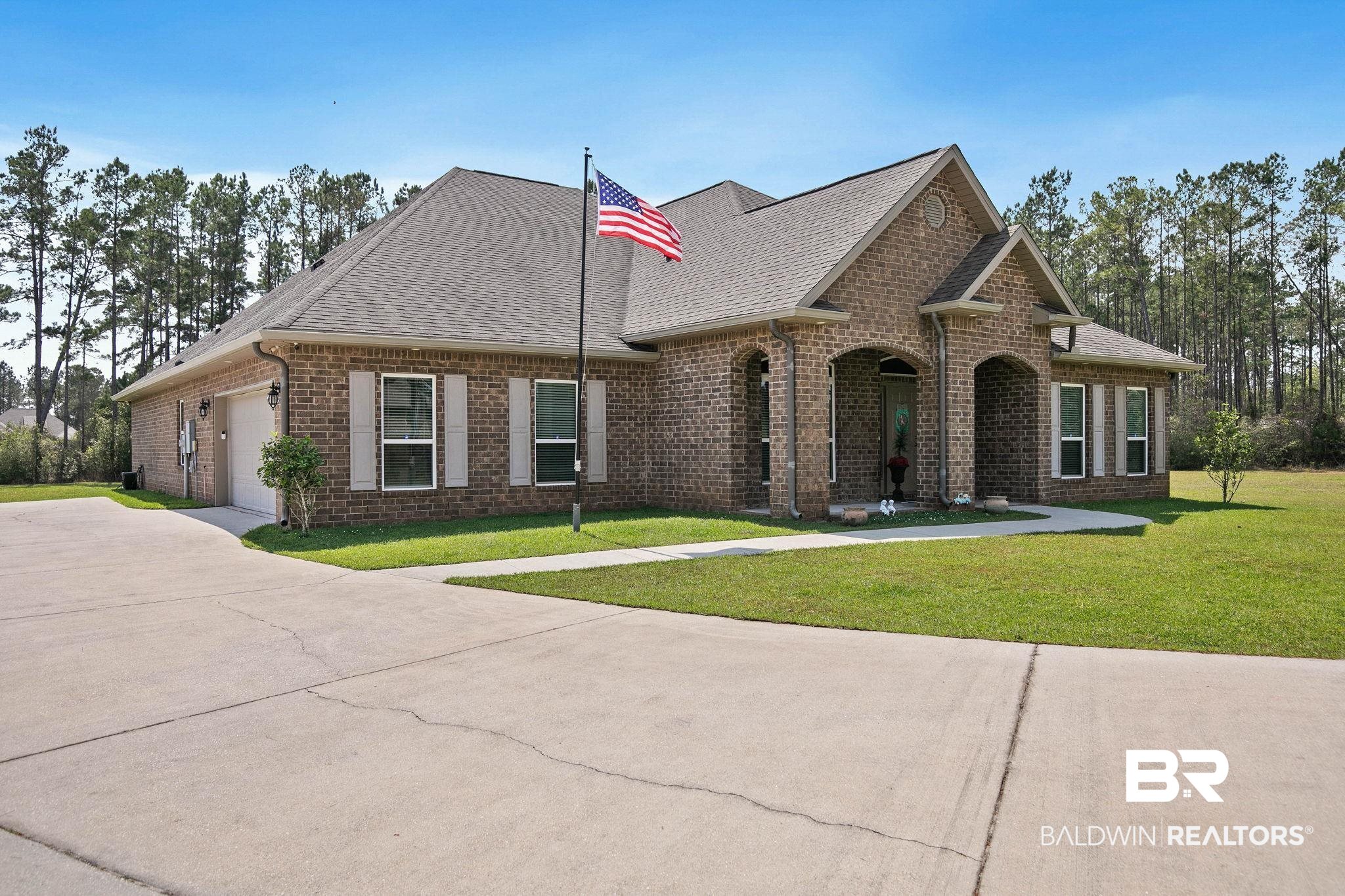12750 B Jenkins Pit Road Daphne, AL 36527 - Photo 65 of 89 View of front of house featuring brick siding, roof with shingles, an attached garage, a front lawn, and concrete driveway