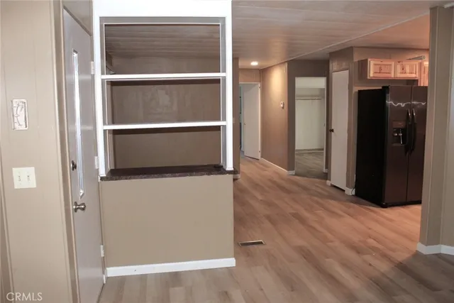 a kitchen with stainless steel appliances granite countertop a refrigerator a sink a stove and wooden floors