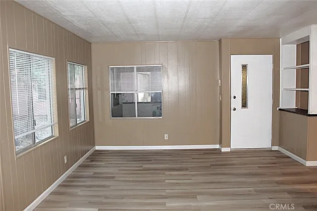 an empty room with wooden floor and a window