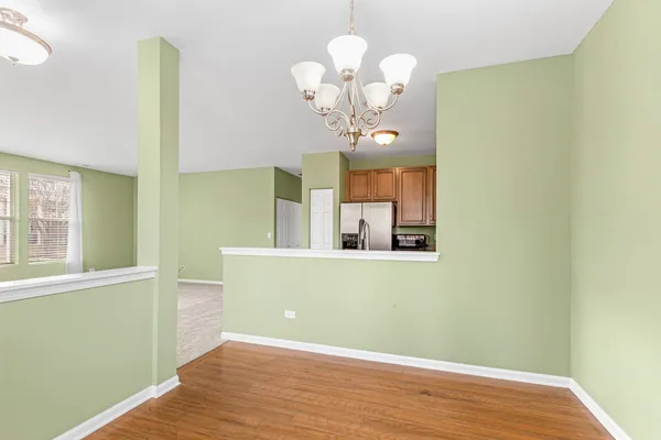 a view of a room with wooden floor chandelier and entryway