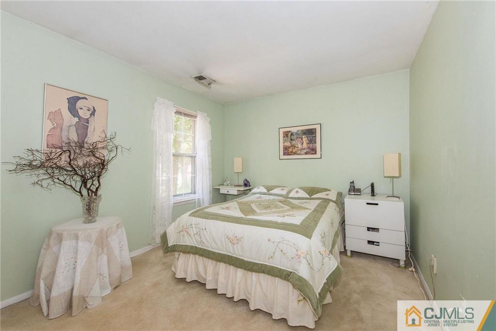8 Woodbury Road Edison, NJ 08820 - Photo 13 of 18 a spacious bedroom with a bed and a window