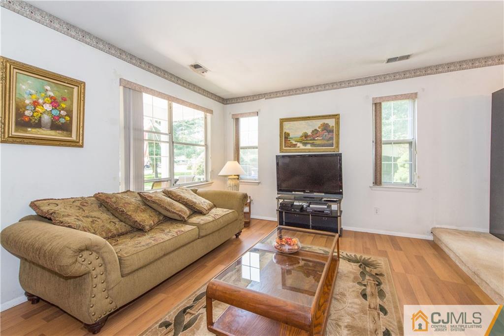 8 Woodbury Road Edison, NJ 08820 - Photo 4 of 18 a living room with furniture and a flat screen tv with wooden floor