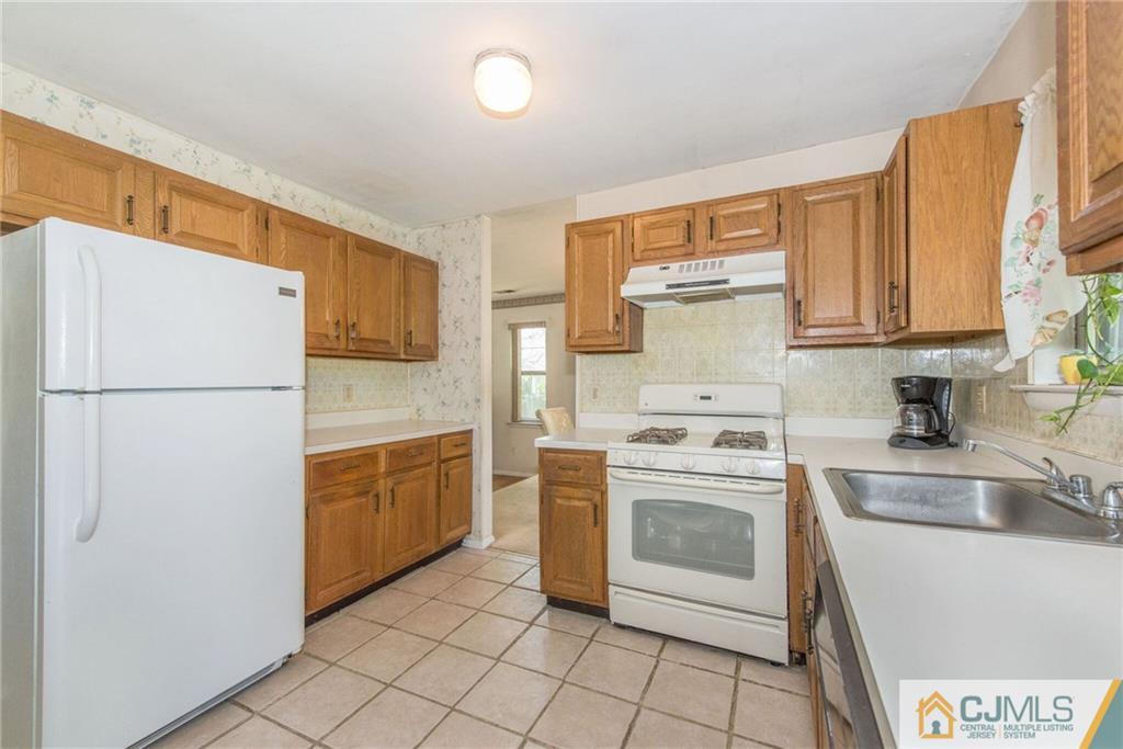 8 Woodbury Road Edison, NJ 08820 - Photo 9 of 18 a kitchen with a stove top oven and refrigerator