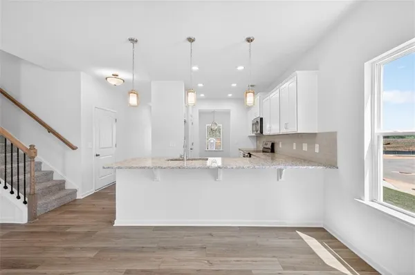 a kitchen with kitchen island granite countertop a sink a center island a counter space and a window