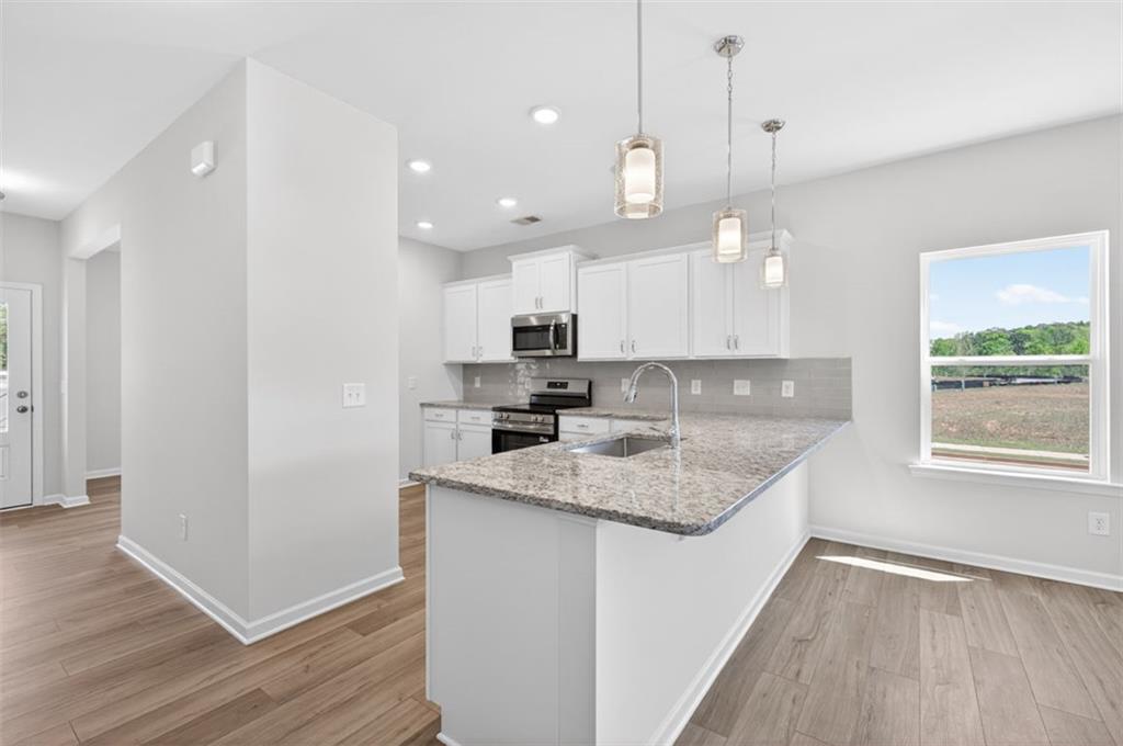 723 Sinclair Lane Temple, GA 30179 - Photo 12 of 40 a kitchen with kitchen island granite countertop a sink a center island a counter space and a window