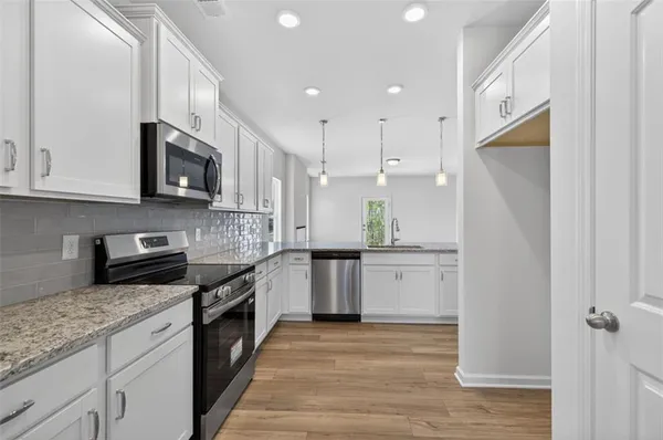 a kitchen with a sink stove and refrigerator