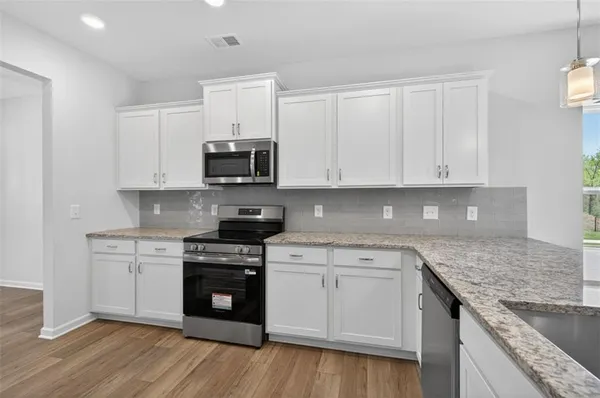 a kitchen with granite countertop a sink and cabinets