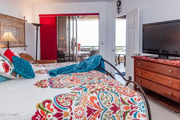 a bedroom with two beds and a flat screen tv