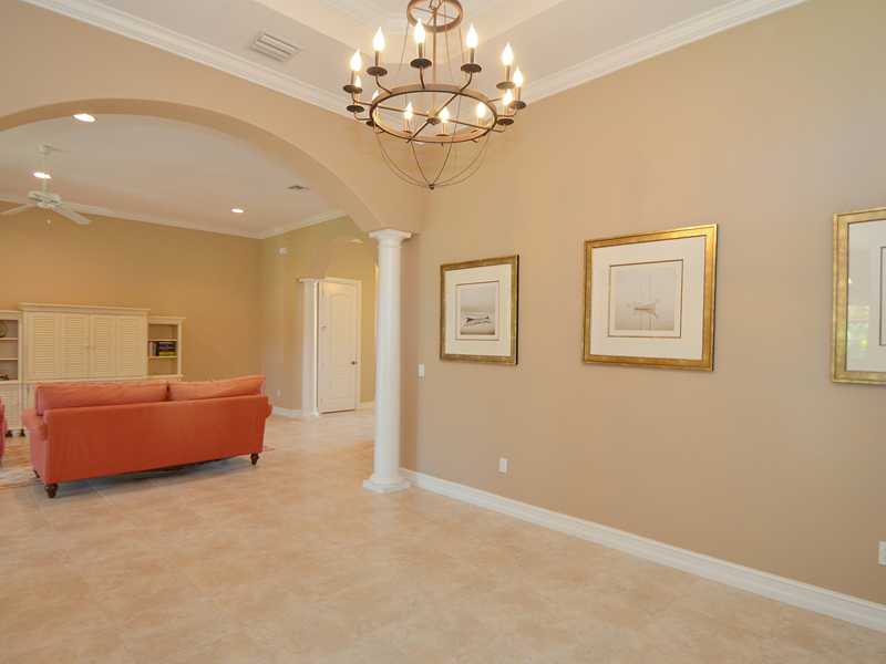 1185 River Wind Circle Vero Beach, FL 32967 - Photo 4 of 29 a spacious bedroom with a bed and a chandelier