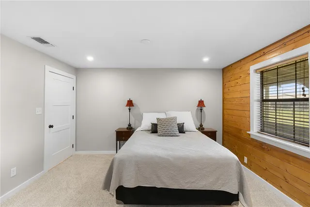 a bedroom with a bed and a large window