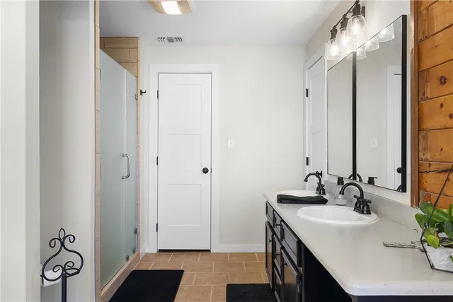 a bathroom with a sink vanity granite and a shower