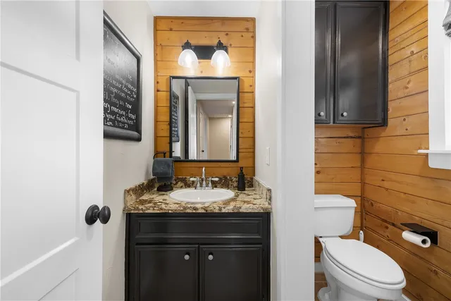 a bathroom with a granite countertop toilet sink and mirror