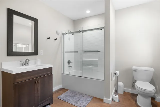 a bathroom with a toilet a sink and mirror